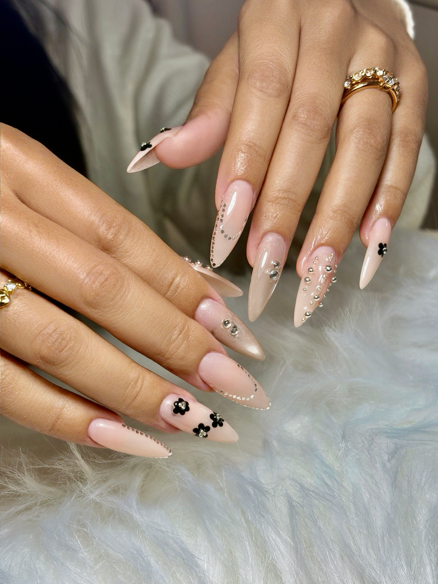Nude almond nails with crystals and black floral accents